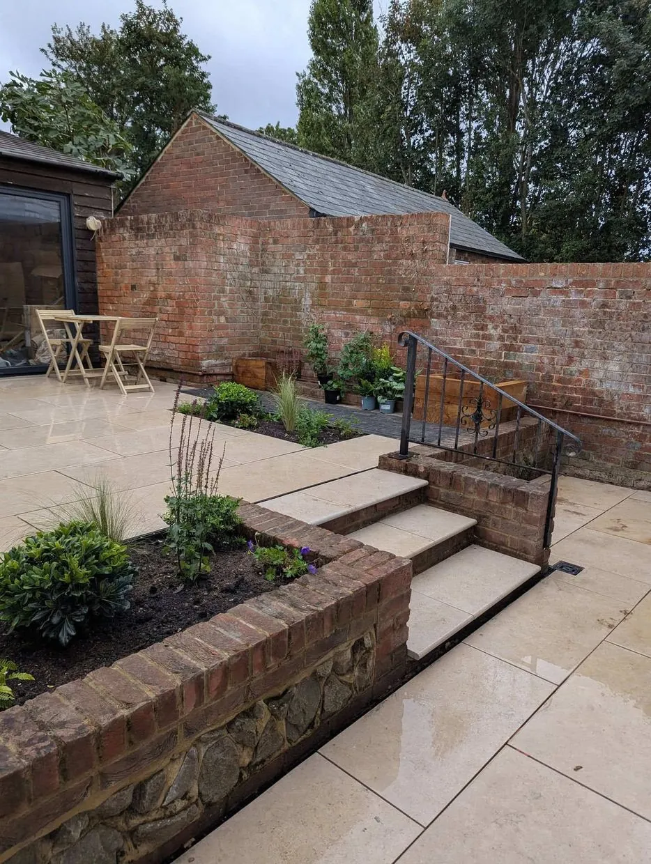 Brick-edged beds and patio steps built by Land & Mortar