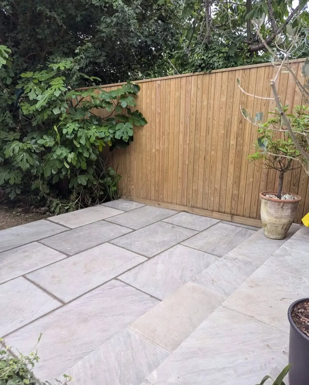 A sandstone patio and new fence by Land & Mortar